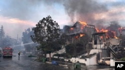 Los bomberos del Departamento de Bomberos de Los Ángeles trabajan para extinguir un incendio en una casa mientras el incendio Palisades arrasa un vecindario en medio de fuertes vientos en el vecindario Pacific Palisades de Los Ángeles, el miércoles 8 de enero de 2025. AP