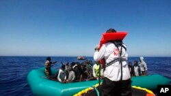 FILE - African migrants on a rubber boat in the Mediterranean Sea, off Libya are rescued by the MV Geo Barents vessel of Doctors Without Borders, in the central Mediterranean route, Monday, Sept. 20, 2021. 