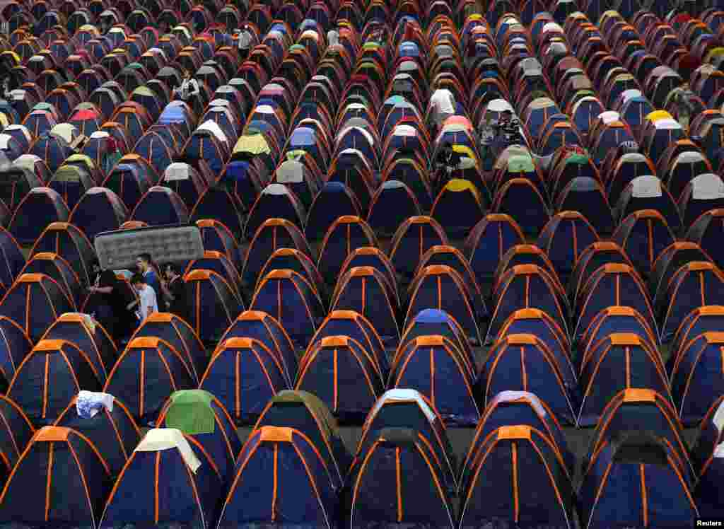 A man carries an inflatable mattress as he arrives at the camping area of the Campus Party event in Sao Paulo, Brazil.