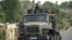 FILE - Ethiopian government soldiers ride in the back of a truck on a road leading to Abi Adi, in the Tigray region of northern Ethiopia, May 11, 2021.