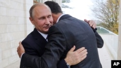 Presiden Rusia Vladimir Putin (kiri) memeluk tamunya Presiden Suriah Bashar Assad kota resor Sochi, Rusia, Senin (20/11).