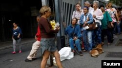 People queue outside a supermarket to buy corn flour and sugar during a blackout in Caracas, Venezuela, March 27, 2019.