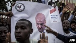 La police se tient devant les partisans du leader de l'opposition en République démocratique du Congo et candidat à la présidence, Martin Fayulu, alors qu'ils participent à une manifestation pour contester les résultats le 11 janvier 2019, à Kinshasa.