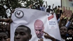 La police se tient devant les partisans de Martin Fayulu, alors qu'ils participent à une manifestation pour contester les résultats de l'élection présidentielle à Kinshasa le 11 janvier 2019. 