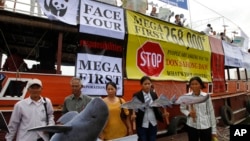 FILE - Cambodian non-governmental organization (NGOs) activists hold a cut-out of Mekong dolphin, left, and cut-out of other species during a protest against a proposed Don Sahong dam, in Phnom Penh, file photo. 