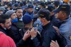 Demonstrators argue with policemen during anti-government protests in Tunis, Tunisia, Jan. 19, 2021.