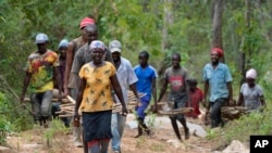 FILE—Residents in Machakos County, Kenya, carry rocks for construction of a sand dam on Thursday, February 29, 2024.