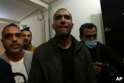 FILE - Algerian journalist Khaled Drareni, center, poses after being released from prison in Algiers, Friday, Feb.19, 2021.