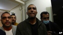 FILE - Algerian journalist Khaled Drareni, center, poses after being released from prison in Algiers, February 19, 2021.