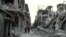 Syrian citizens walk in a destroyed street that was attacked on Wednesday by Syrian forces warplanes, at Abu al-Hol street in Homs province, Syria, Nov. 29, 2012.