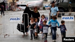 Nearly 2 million Syrians have fled the country since the civil war started 29 months ago. This Syrian family is shown walking along the Turkish-Syrian border on May, 12, 2013.