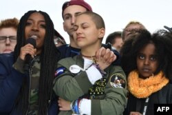 FILE - Marjory Stoneman Douglas High School student Emma Gonzalez, center, listens with other students during the March for Our Lives Rally in Washington, March 24, 2018.