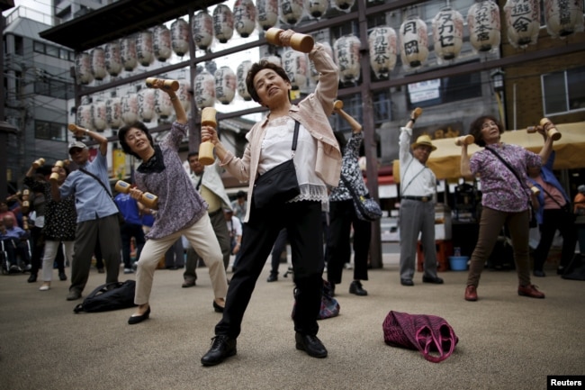 Warga lansia dan paruh baya di Jepang sedang berolahraga dalam acara promosi kesehatan memperingati “Hari Lansia” di sebuah kuil di distrik Sugamo, di Tokyo, 21 September 2015.