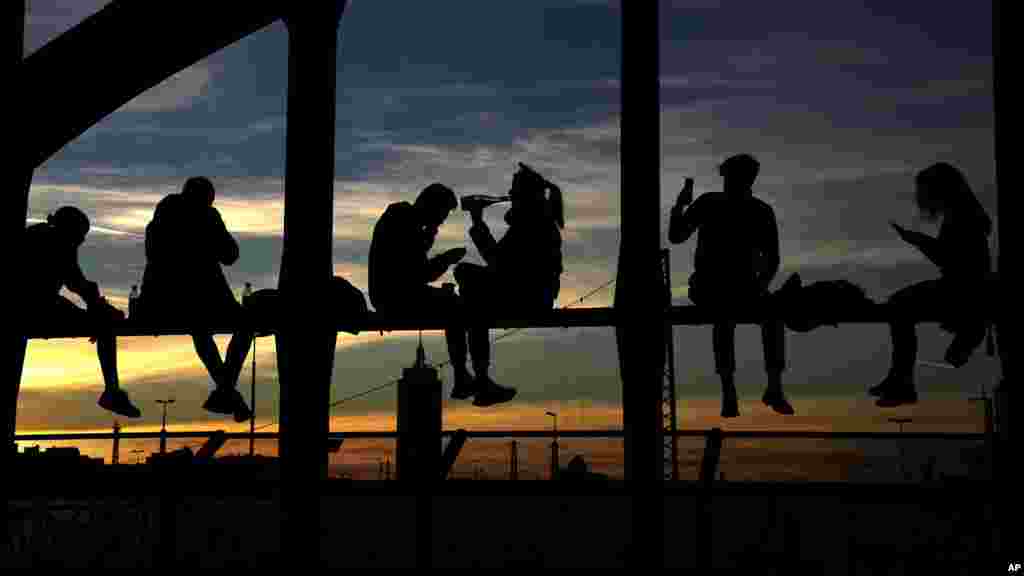 People drink wine, take pictures and enjoy the sunset at the bridge &#39;Hackerbruecke&#39; in Munich, Germany, Oct. 31, 2021.