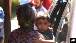 Un niño de Honduras es traído a la oficina de Inmigración y Control de Aduanas en Grand Rapids, Mich., July 10, 2018. Un juez ha ordenado la suspensión de las deportaciones de familias migrantes separadas en la frontera sur de EE.UU.