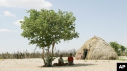 Two Basarwa women hide from the scorching sun in Metsiamenong, a remote village in the heart of the Central Kalahari Game Reserve, Botswana. (2007 file photo)