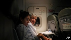 Mexican President Andres Manuel Lopez Obrador, center, sits with an assistant as he travels in economy class aboard a commercial flight from Guadalajara to Mexico City, Saturday, March 9, 2019. 