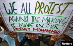 A man holds a poster containing statements against the making of an anti-Islam film in Jammu, India, September 21, 2012.