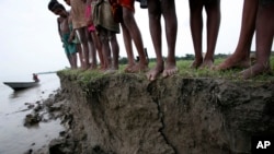 FILE - A group of Bangladeshi village children who have lost their homes due to erosion near the riverbed stand on the banks of the river Jamuna, in Manikgonj, 40 kilometers north of the Bangladesh capital of Dhaka, July 4, 2008. 
