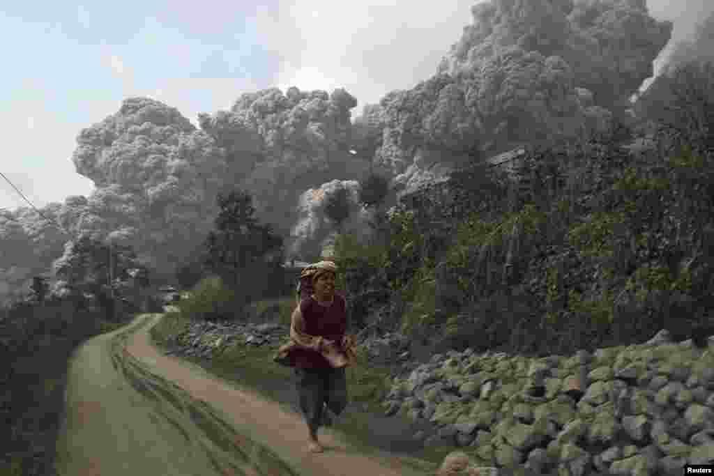 A villager runs as Mount Sinabung erupts at Sigarang-Garang village in Karo district, Indonesia&#39;s North Sumatra province.