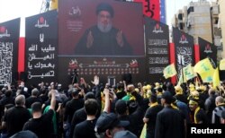 FILE - Lebanon's Hezbollah leader Hassan Nasrallah gestures as he addresses supporters via video screen, in Beirut, Lebanon, Sept. 10, 2019.
