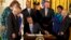 Surrounded by LGBT supporters, President Barack Obama signs executive orders to protect LGBT employees from federal workplace discrimination, in the East Room of the White House in Washington, July 21, 2014.