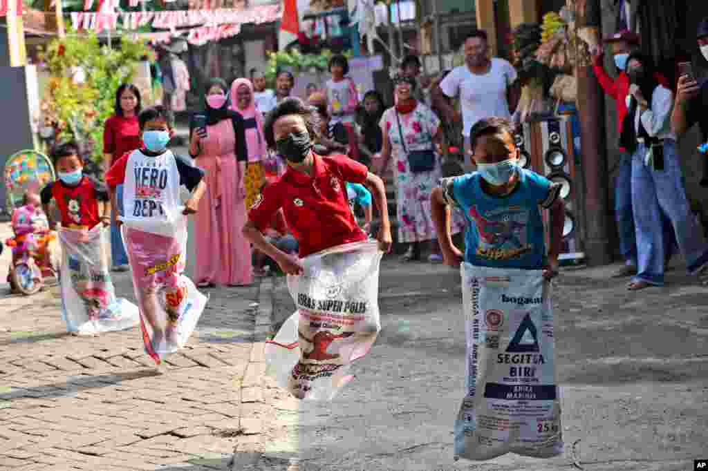 کودکان مشغول بازی پریدن با گونی در جشن‌های روز استقلال در جاکارتا، اندونزی