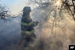 Firefighters respond to a brush fire in Suffolk County in New York's Long Island, March 8, 2025. (Steve Pfost/Newsday via AP)