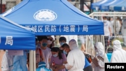 北京市民在广安体育中心外排队接受新冠病毒检测。（2020年6月15日）