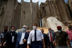 French President Emmanuel Macron gestures as he visits the devastated site of the explosion at the port of Beirut, Lebanon, Aug. 6, 2020.