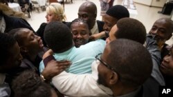 FILE - Paulette Carrington (C), a former juvenile lifer and participant in Uplift Solutions' job training program for former inmates, is embraced by her classmates during a graduation ceremony in Philadelphia, Oct. 16, 2017. 