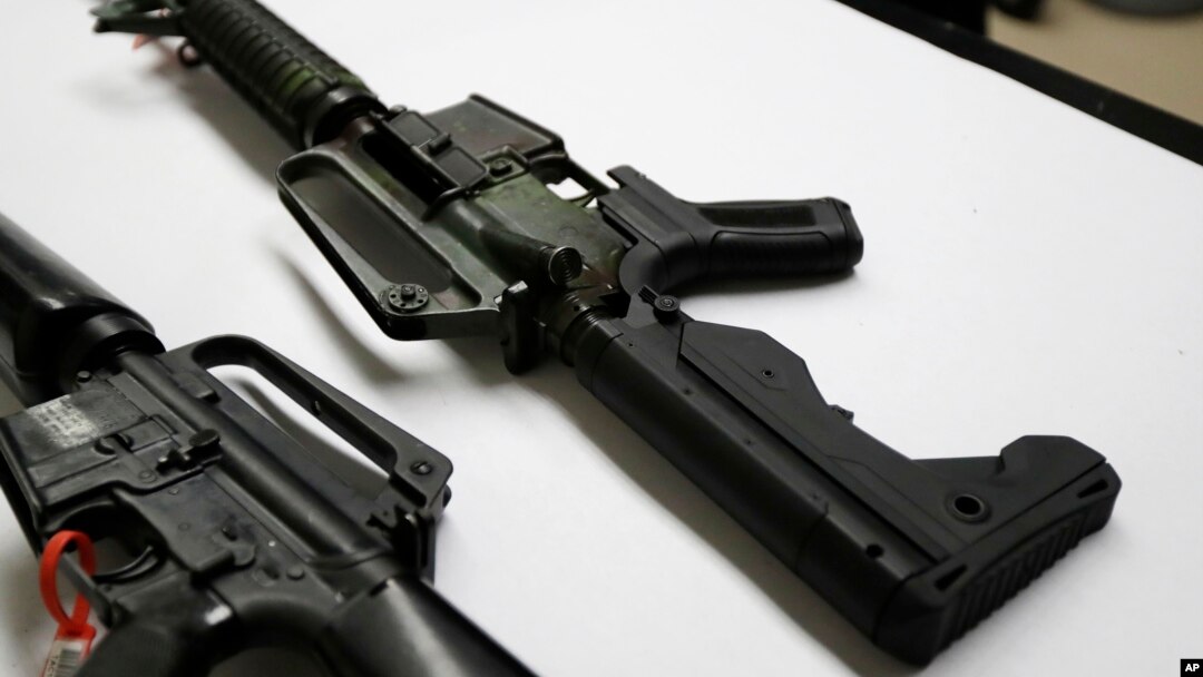 FILE - In this Jan. 11, 2018, photo, a semi-automatic rifle at right that has been fitted with a so-called bump stock device to make it fire faster, sits on a table at the Washington State Patrol crime laboratory in Seattle.