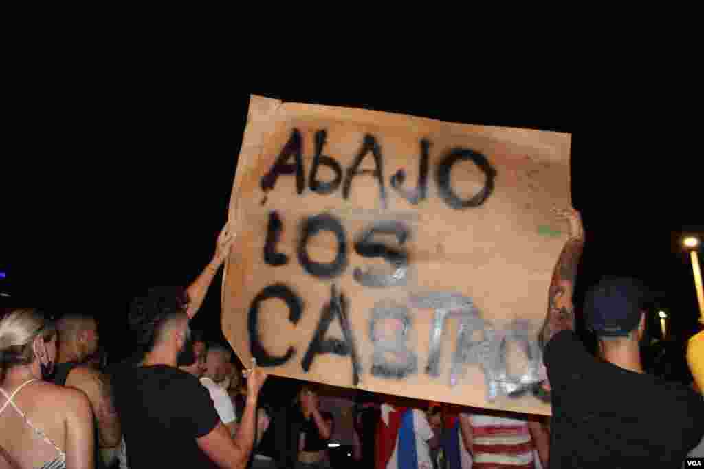 Exiliados portan un cartel contra el gobierno comunista de Cuba, en manifestaci&#243;n en la Calle 8 en Miami, Florida, en apoyo a las protestas sucedidas en la isla el domingo 11 de julio de 2021. Foto: Luis F. Rojas, VOA.