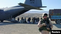 FILE - Photo of a US soldier guarding a shipment of Afghan ballots at Karshi-Khanabad Air Base in Uzbekistan in 2004.