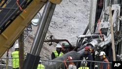 Rescue workers insert steel pipes to encase the escape tunnel that will be used to free trapped miners at the San Jose mine near Copiapo, Chile, 10 Oct 2010