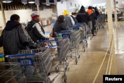 FILE - Clients wait in line to shop for food at the St. Vincent de Paul food pantry in Indianapolis, Indiana, in November 2012.