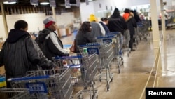 مشتریان در صف انتظار برای خرید مواد غذایی در کليسايی در ایندیاناپولیس، ايالت ایندیانا