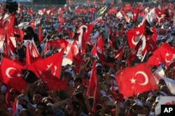 FILE - In this Sunday, July 9, 2017, photo, supporters of Kemal Kilicdaroglu, the leader of Turkey's main opposition Republican People's Party, hold Turkish flags in Istanbul, as they gather for a rally following their 425-kilometer (265-mile) "March for Justice."