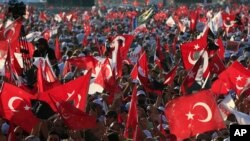 FILE - In this July 9, 2017 photo, supporters of Kemal Kilicdaroglu, the leader of Turkey's main opposition Republican People's Party, hold Turkish flags in Istanbul, as they gather for a rally following their 425-kilometer (265-mile) "March for Justice." 