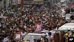 លោក​ស្រី អ៊ុង សានស៊ូជី មេដឹកនាំ​គណបក្ស​ខាង​ប្រជាធិបតយ្យ​នៃ​ប្រទេស​ភូមា​លើក​ដៃ​ទៅ​អ្នកគាំទ្រ ថ្ងៃទី១០ មីនា ២០១២។