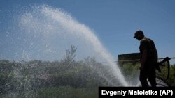 Наприкінці квітня унаслідок влучання ракет у системи водопостачання у Миколаєві питна вода зникла на декілька тижнів. Люди набирали воду з калюж, річок, очищали доступними способами та пили. AP Photo/Evgeniy Maloletka.