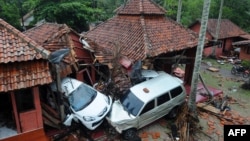 Bangunan-bangunan dan mobil-mobil yang rusak di Anyer, Serang, Minggu, 23 Desember 2018, setelah kawasan itu dilanda tsunami akibat letusan Gunung Anak Krakatau pada Sabtu, 22 Desember 2018. (Foto: AFP)