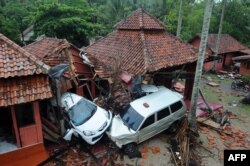 Bangunan-bangunan dan mobil-mobil yang rusak di Anyer, Serang, Minggu, 23 Desember 2018, setelah kawasan itu dilanda tsunami akibat letusan Gunung Anak Krakatau pada Sabtu, 22 Desember 2018. (Foto: AFP)