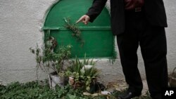 Seorang pria menunjukkan makam Soheir el-Batea, remaja puteri Mesir yang meninggal setelah menjalani mutilasi kelamin di kota Aga (5/11).