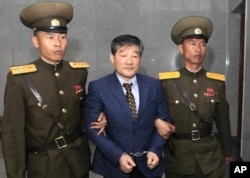 FILE - Kim Dong Chul, center, a U.S. citizen detained in North Korea, is escorted to his trial in Pyongyang, North Korea.