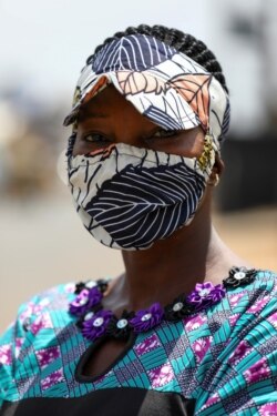 Penata busana Nigeria Angela Innocent, 38, berpose untuk berfoto dengan masker yang serasi dengan pakaiannya, di Lagos, Nigeria 14 Mei 2020. (Foto: REUTERS/Temilade Adelaja)