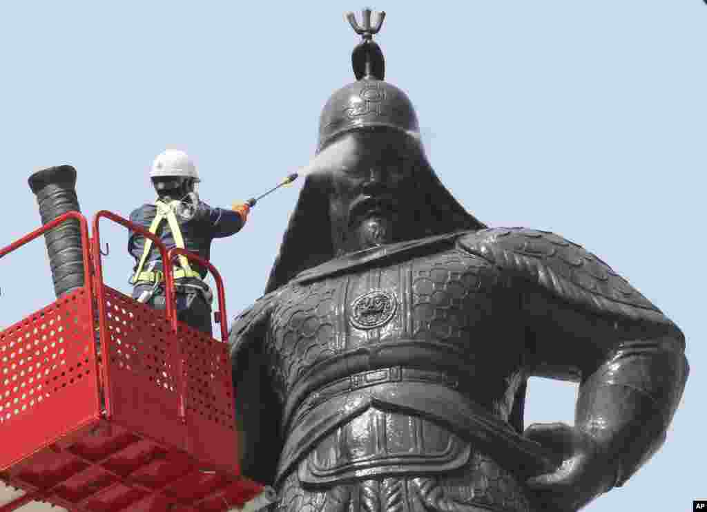A South Korean worker cleans a statue of Admiral Yi Sun-sin ahead of the coming of spring at Gwanghwamun Plaza in Seoul.