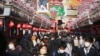 People wearing face masks to protect against the spread of the coronavirus walk under decorations for new year through the alley leading to Asakusa Sensoji Buddhist temple in Tokyo, Dec. 21, 2021. 