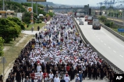 FILE - Kemal Kilicdaroglu, the leader of Turkey's main opposition Republican People's Party, walks with thousands of supporters on the 21st day of his 425-kilometer (265-mile) " March for justice " in Izmit, Turkey, July 5, 2017.