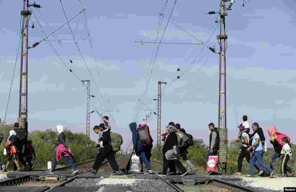Migrants cross railway lines as they walk towards the border crossing with Austria in Hegyeshalom, Hungary.